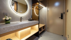 Un baño moderno con un espejo grande, un lavabo y un mueble de tocador de madera.
