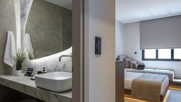 A modern bathroom with a large sink, mirror, and towel rack.