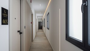 A modern hotel corridor with a sign for 'Loena Luxury Suites' at number 405. - Loena Luxury Suites (Thessaloniki)