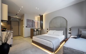 A modern hotel room with a large bed, a desk, and a dining area. - Loena Luxury Suites (Thessaloniki)