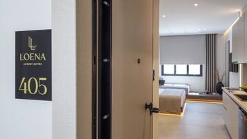 Una habitación de hotel moderna con una cama grande, un escritorio pequeño y vistas a la ciudad.