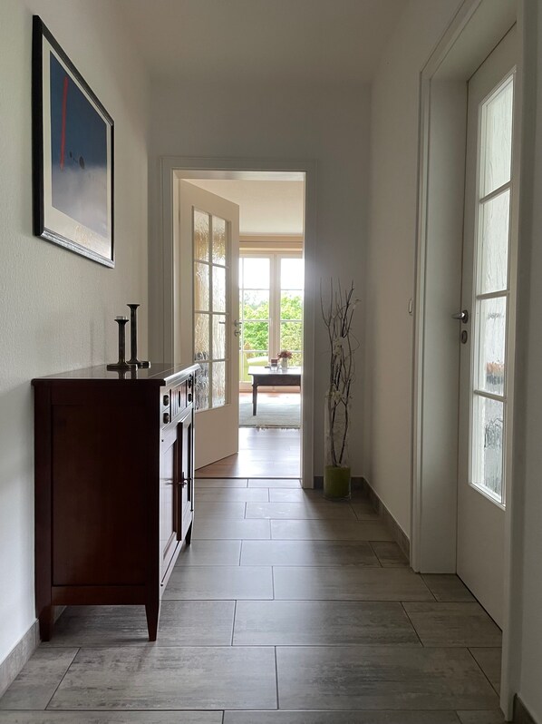Ein Flur mit einem Holzschrank, einem gerahmten Bild an der Wand und einem Blumentopf.
