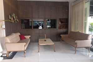 A modern living room with two sofas, a coffee table, and a large cabinet with glass doors. - Golden Star Pattaya (Pattaya)