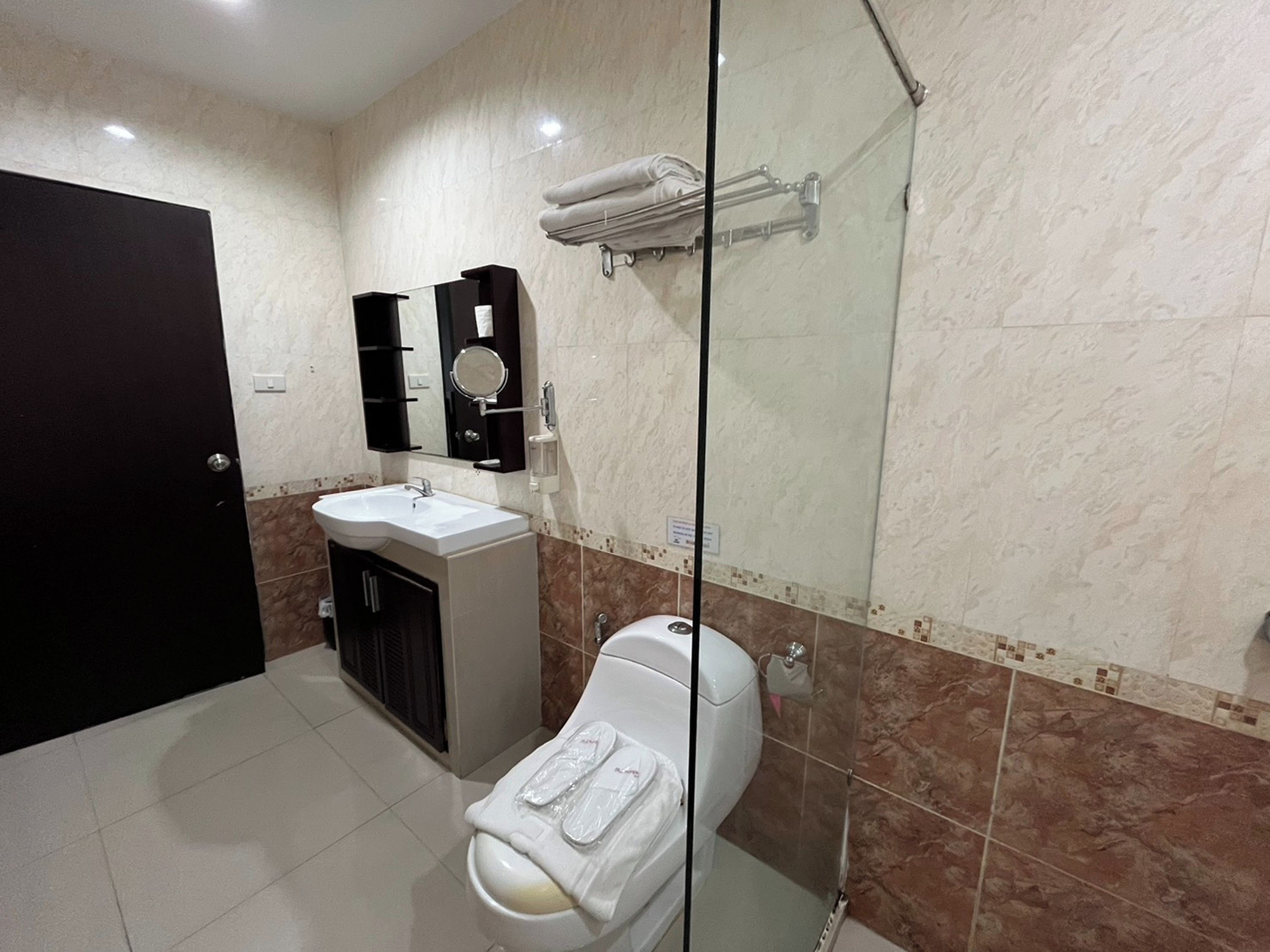 A modern bathroom with a toilet, sink, and glass shower enclosure.