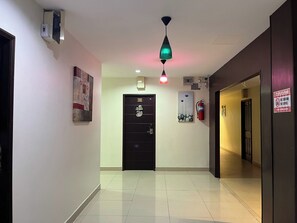 A hallway with a fire exit door, emergency equipment, and a fire extinguisher.