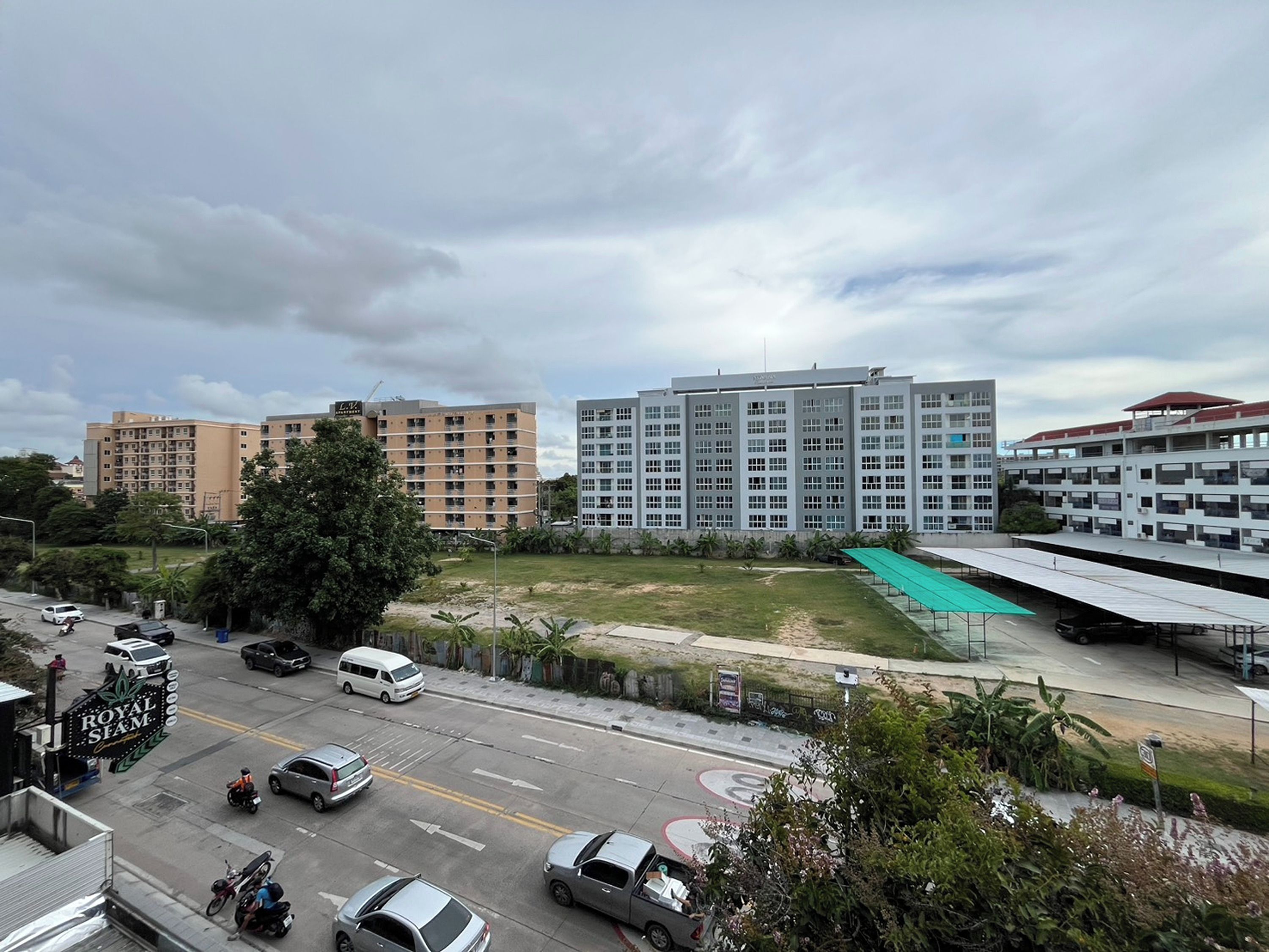 A multi-story building with a flat roof and a parking lot in front.