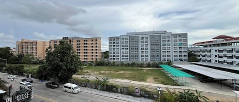 A multi-story building with a flat roof and a parking lot in front.