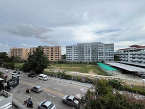 A multi-story building with a flat roof and a parking lot in front.