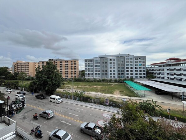 A multi-story building with a flat roof and a parking lot in front.