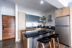 Una cucina moderna con isola centrale, elettrodomestici in acciaio inossidabile e mobili in legno.