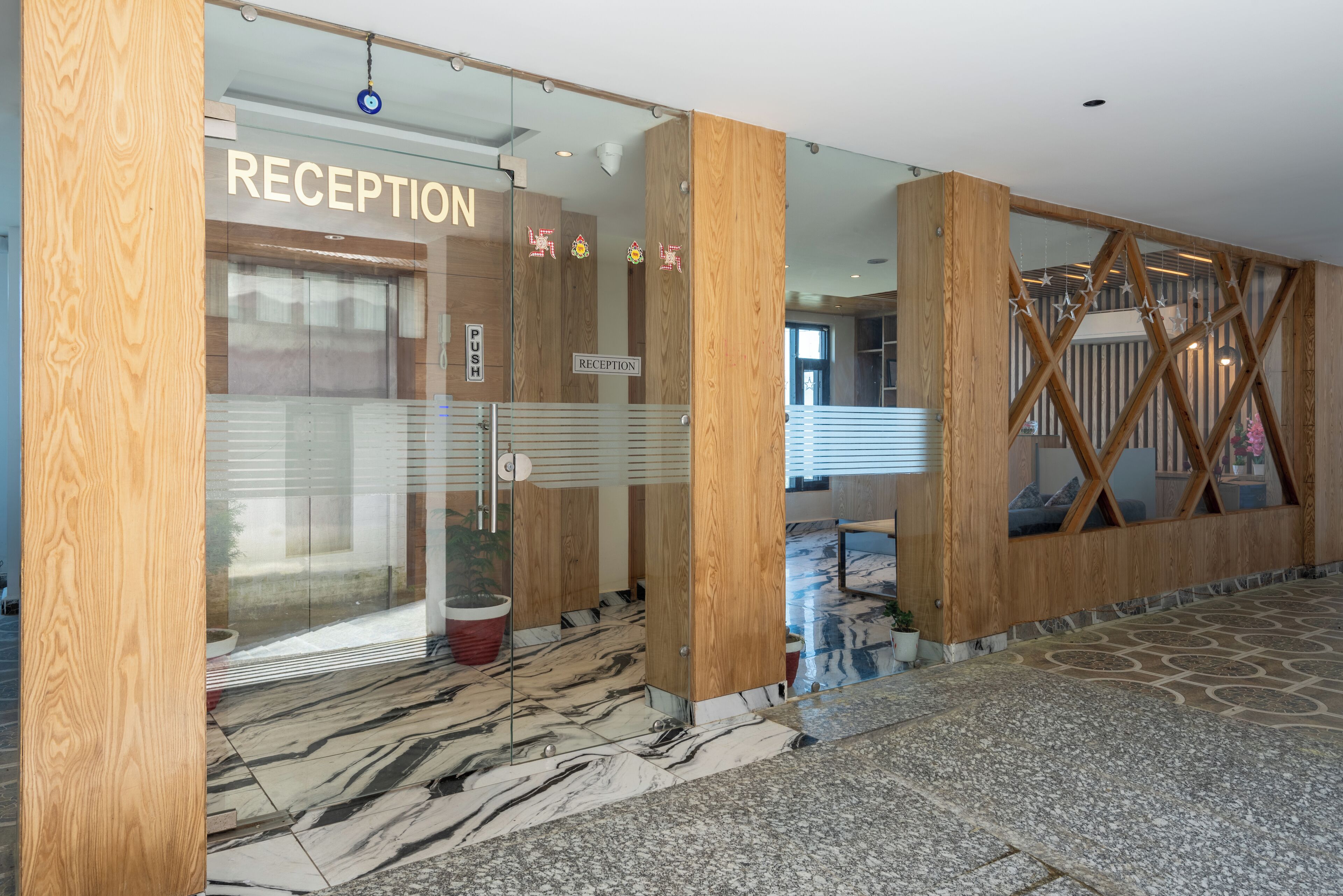 A reception area with a marble floor, wooden accents, and a glass door.