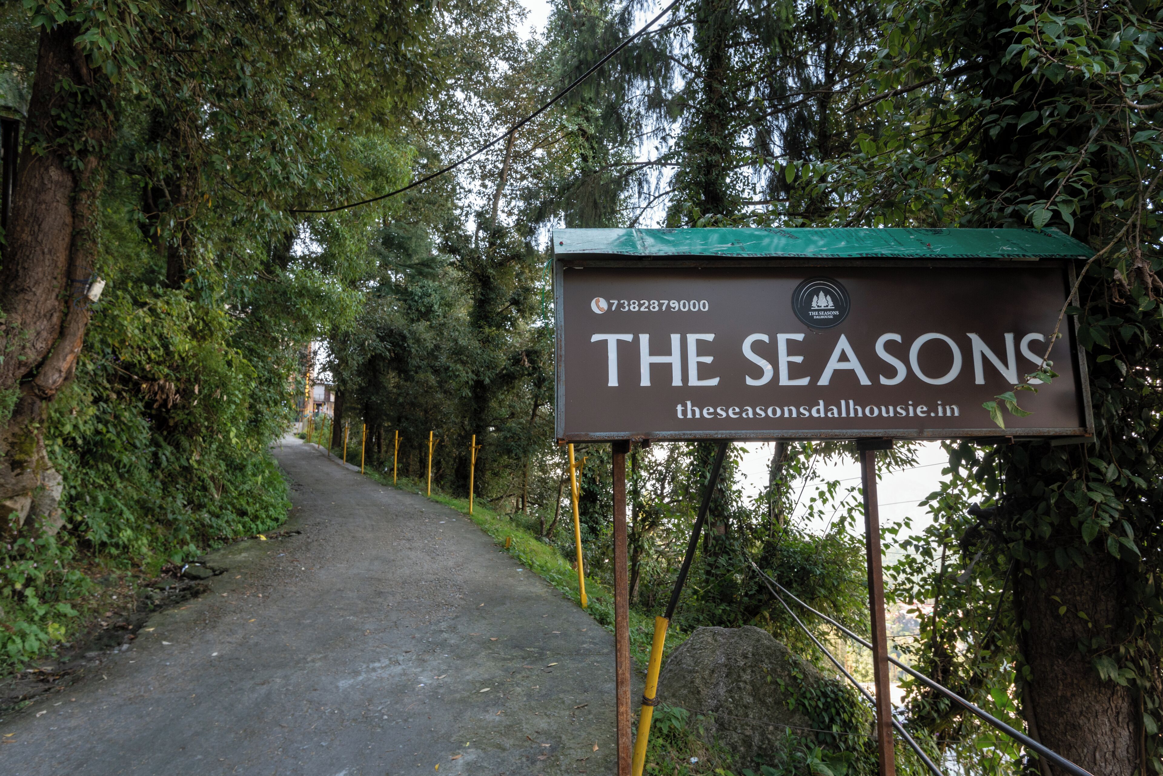 Un cartel para el hotel 'The Seasons', con un número de contacto y sitio web.