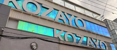 Un edificio con una gran señalización iluminada que dice 'KOZAYO'.