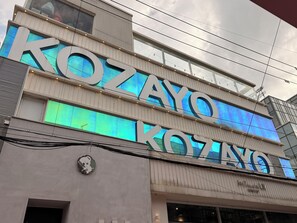 Un bâtiment doté d’une grande enseigne lumineuse sur laquelle on peut lire « KOZAYO ».