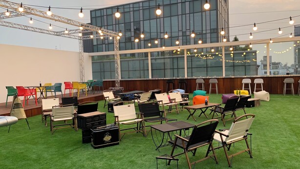 A rooftop terrace with outdoor seating, a bar area, and string lights. - KOZAYO Hongdae Hostel (Seoul)