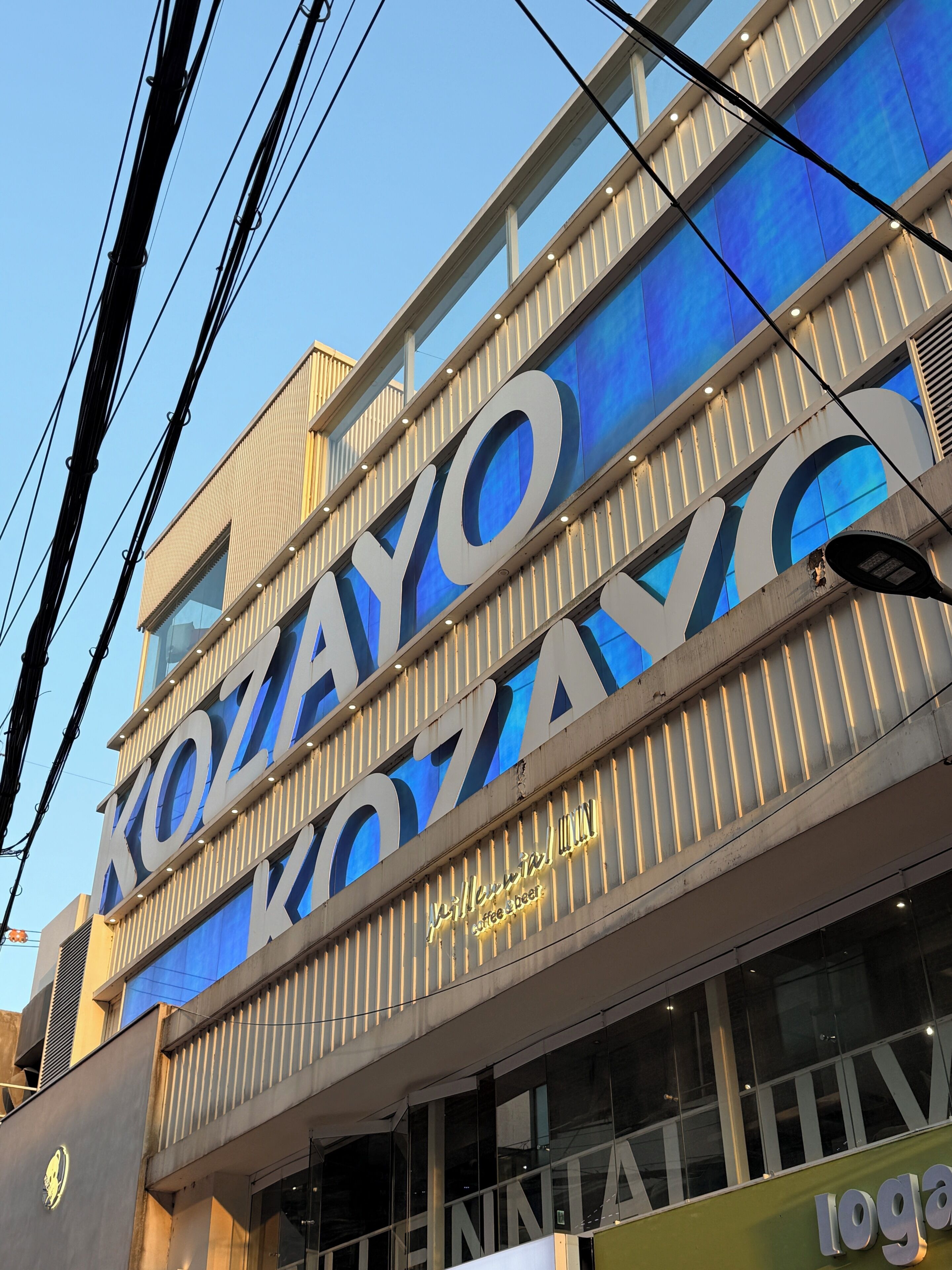 A building with large illuminated signage for 'Kozayo Coffee & Beer'.