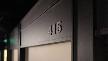 A close-up of a dark wooden door with the number '415' indicating a room or location.