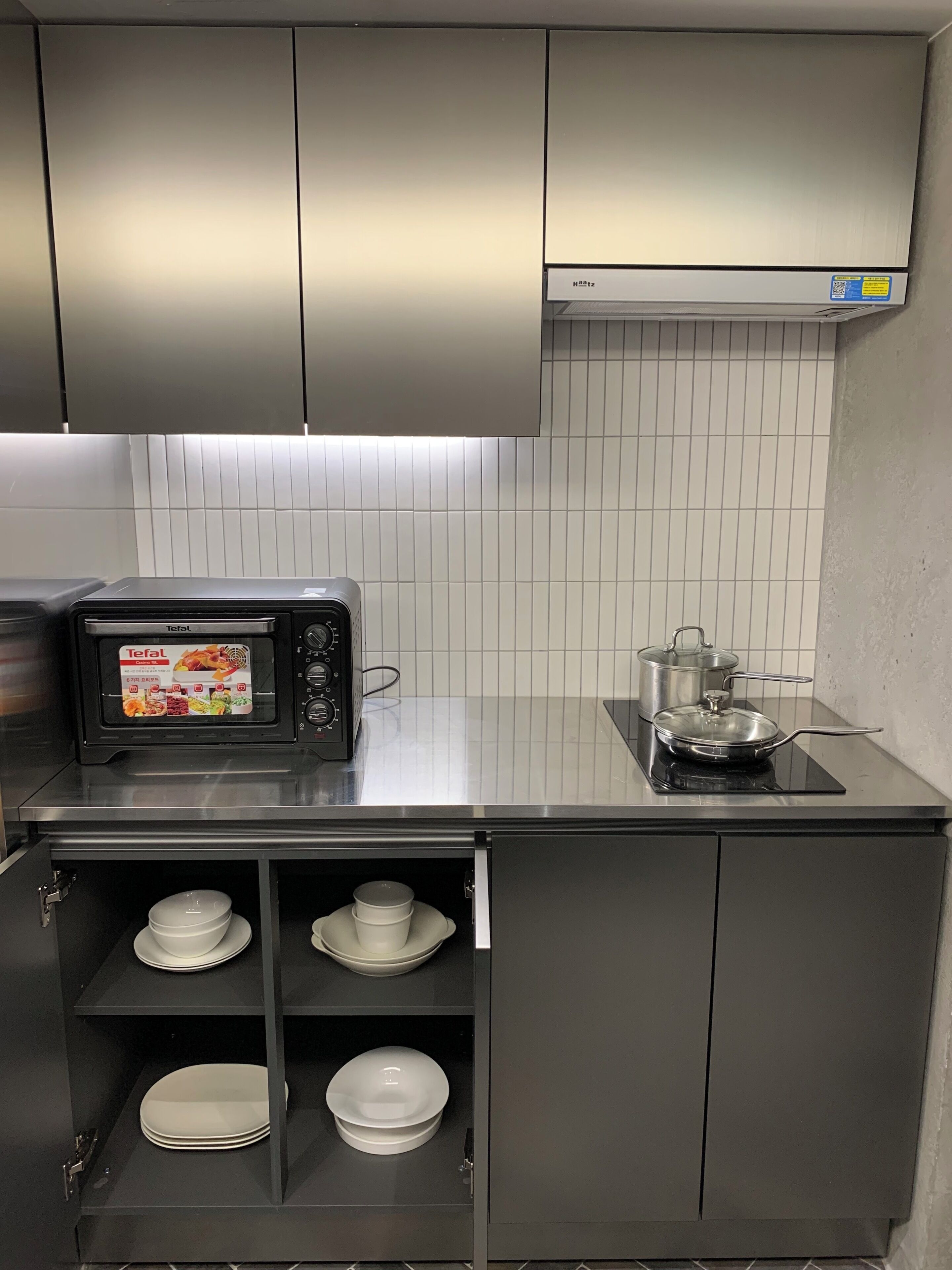 Una cocina con microondas, estufa y armarios.