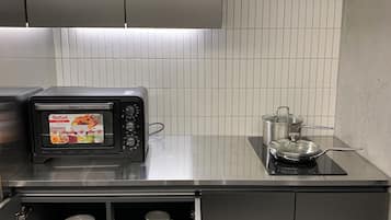 A kitchen with a microwave, stove, and cabinets.
