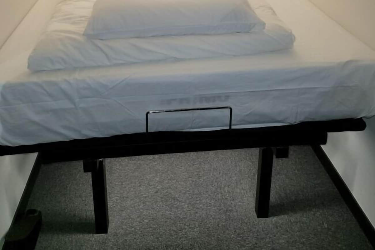 A small, single-bed room with a simple, clean design.