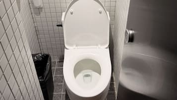 A white toilet with a closed lid in a tiled bathroom.