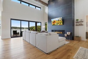 Cozy living area with a large sectional sofa and fireplace, offering a view of the outdoors.