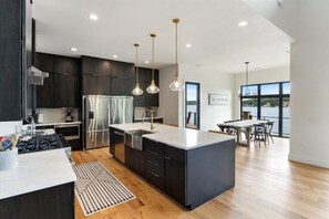Enjoy cooking in this well-lit kitchen with a central island, sink, and stainless steel appliances.