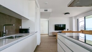A modern kitchen with a built-in oven, a large window, and a flat-screen TV. - ASTER sweet apartment (Villajoyosa)