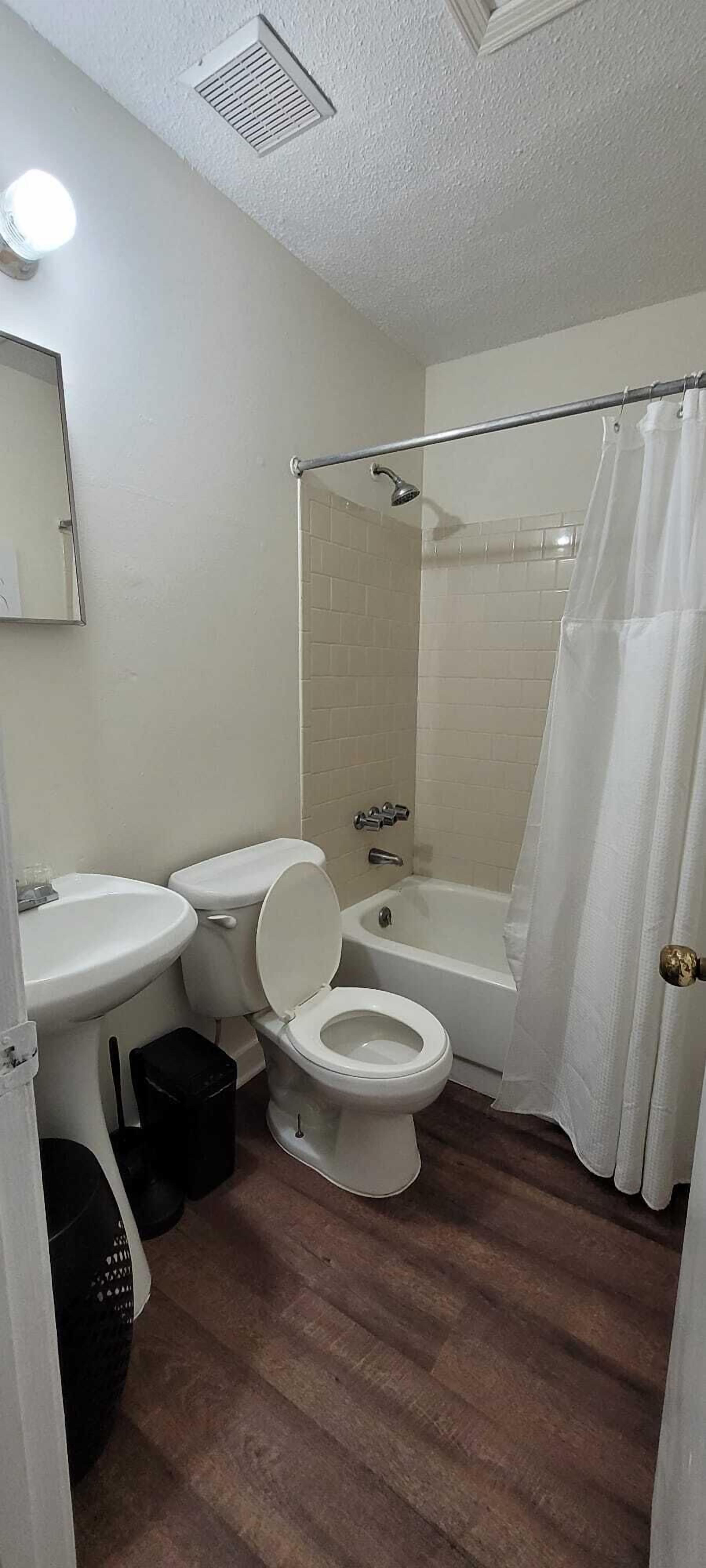 A bathroom with a toilet, sink, and bathtub.