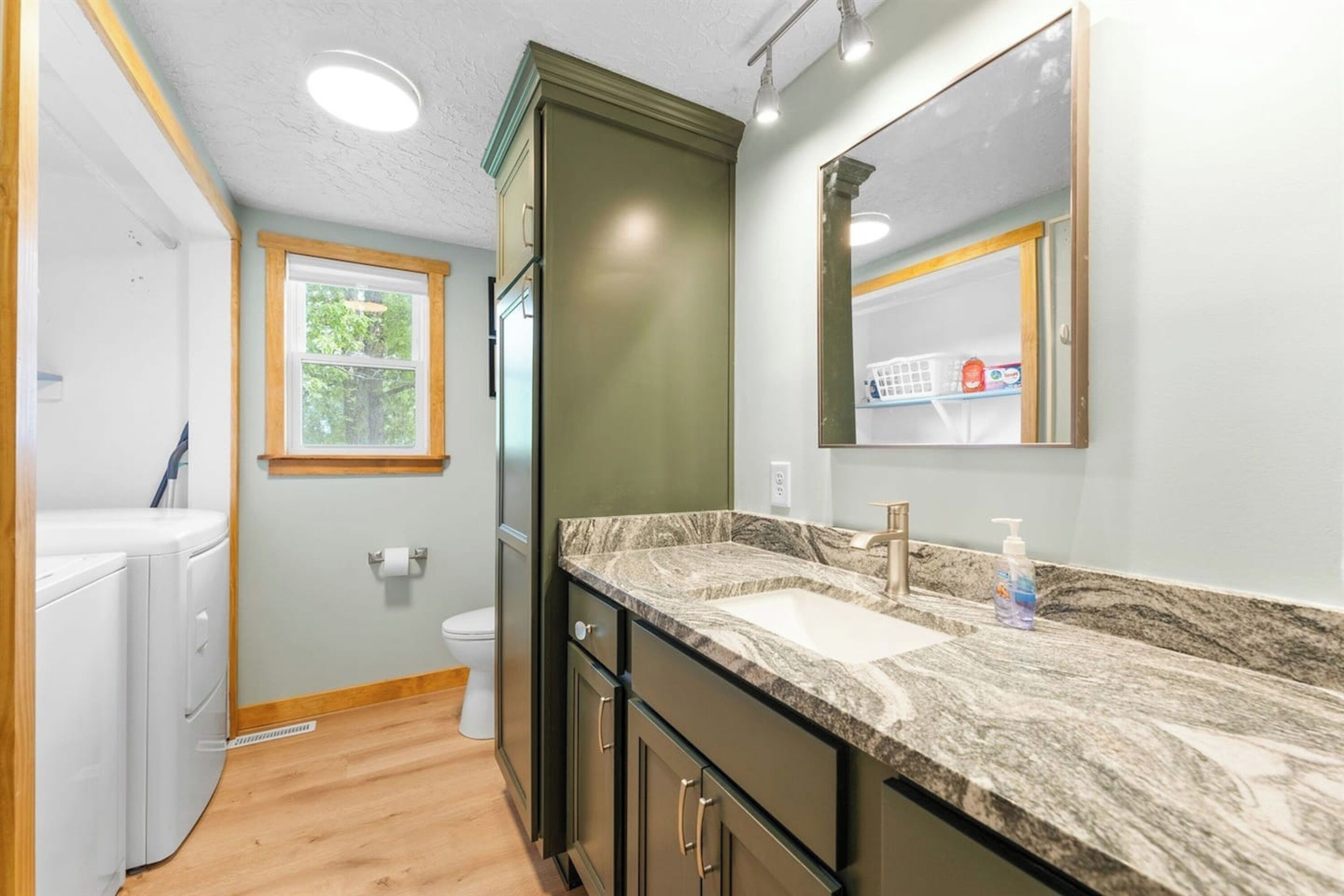 Une salle de bain avec un lavabo, un miroir et des toilettes.