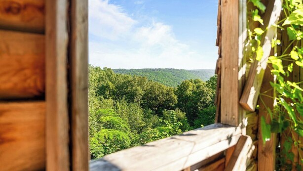 A wooden cabin with a view of a forested mountain range. - Branson's Crystal Cabin (Omaha)