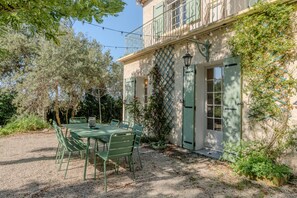 A building with a balcony, a table with chairs, and a door. - Villa Lelix • Vineyards, Peace, Large Pool (Carpentras)