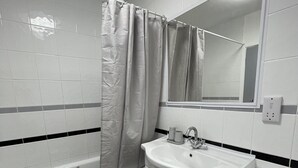 Ein Badezimmer mit Badewanne, Waschbecken, Toilette und Spiegel.