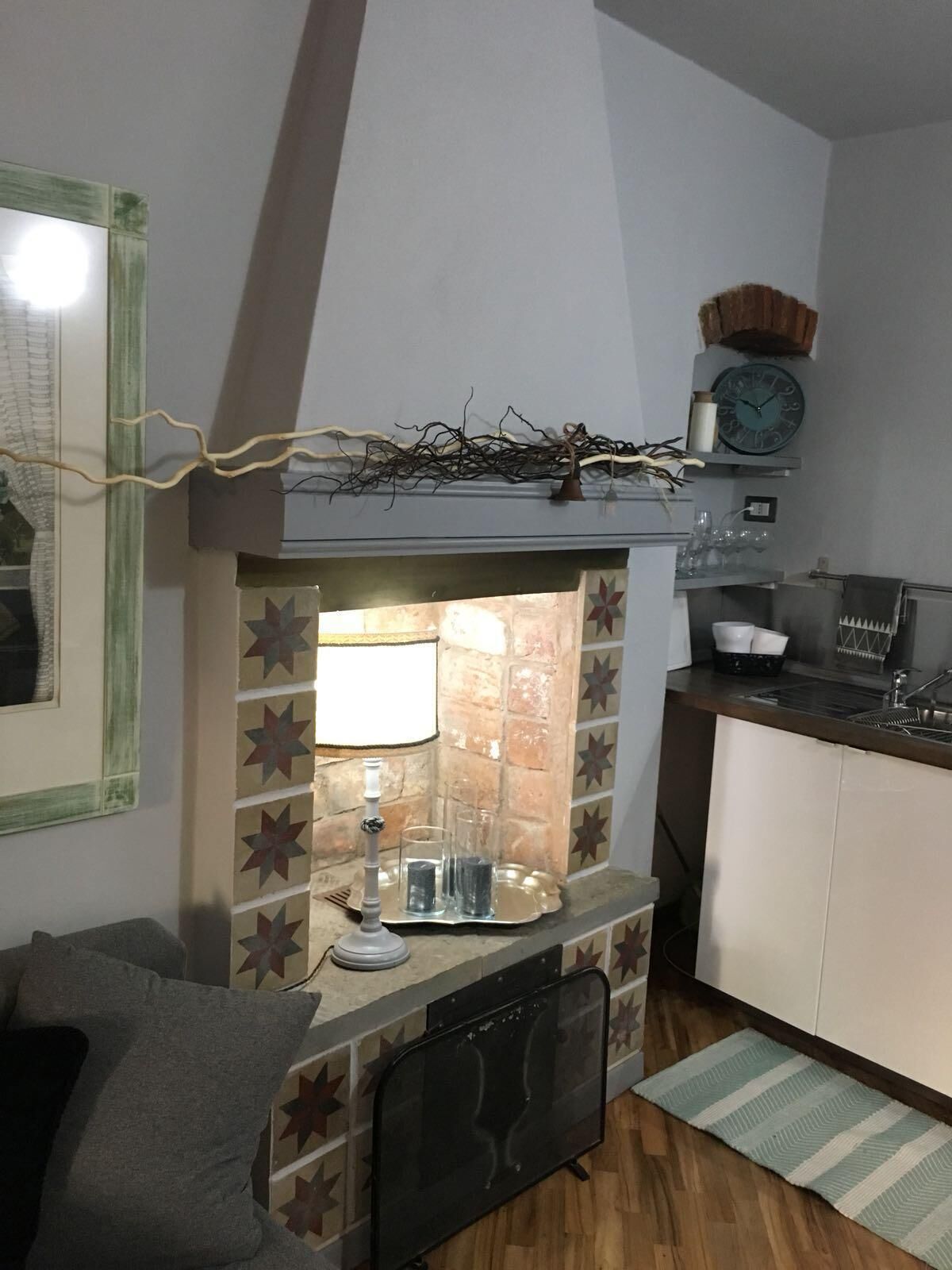 A compact kitchen with a built-in stove, a clock, and a small shelf above the stove.