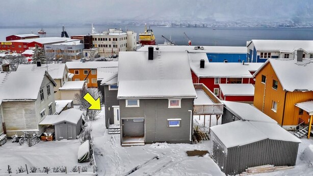 Ein Wohngebiet mit schneebedeckten Häusern und Blick auf das Wasser.