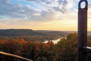A scenic view of a lake surrounded by autumn-colored trees and hills. - Container Home (Omaha)