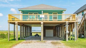 A two-story wooden house with a balcony and a covered porch.