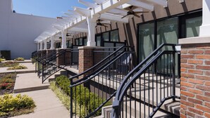 A building with a covered outdoor area, numbered units, and a brick facade. - Charming Space with Parking/King Bed/Street Car (Kansas City)
