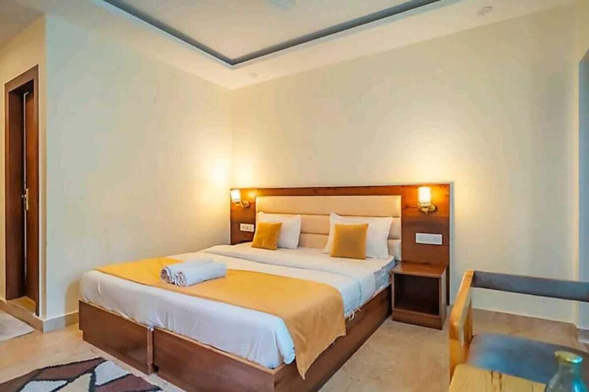 A neatly arranged bedroom with a large bed, bedside tables, and a chair.