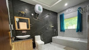Un baño moderno con una bañera grande, un inodoro, un lavabo y una ducha.