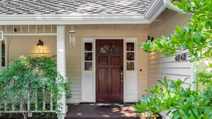 A house with a brown front door, a white porch, and a mailbox. - Spacious 3BR Redmond Home with Fireplace & BBQ (Redmond)