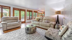 A spacious living room with two leather sofas, a round coffee table, and a white shag rug. - Spacious 3BR Redmond Home with Fireplace & BBQ (Redmond)