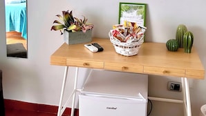 A compact living space with a wooden desk, a small white fridge, a television mounted on the wall, and a mirror on the left. - Delightful and spacious apartment with a view of Vesuvius - Salotto Napoletano 381 (Napoli)