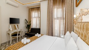 A hotel room with a bed, a desk with a flat-screen TV, a chair, a potted plant, and a large window with curtains. - Felicity Palace Sirkeci (Istanbul)