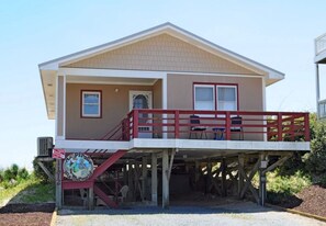 A two-story house with a balcony, a front door, and a small porch area.
