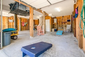 A spacious room with a concrete floor, wooden walls, and a metal ceiling structure. - Almost Beachfront - Cozy 2nd Row Home with 4 Bedrooms (Surf City)