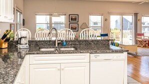 A kitchen with a granite countertop, white cabinets, a coffee maker, and a dishwasher. - Almost Beachfront - Cozy 2nd Row Home with 4 Bedrooms (Surf City)
