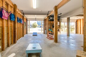 Un espacio interior amplio con paredes de madera, suelo de hormigón y una mesa central.