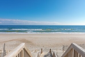 Ein Strand mit einer Holzpromenade, die zum Wasser führt.