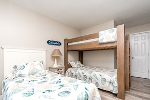 Ein Schlafzimmer mit zwei Etagenbetten, einer Nachttischlampe und einem Schild an der Wand.